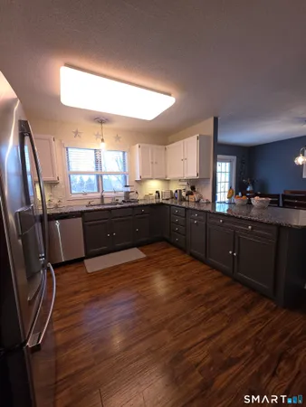 a large kitchen with wooden floors and stainless steel appliances