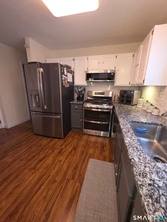 a bathroom with a sink a toilet and a large mirror