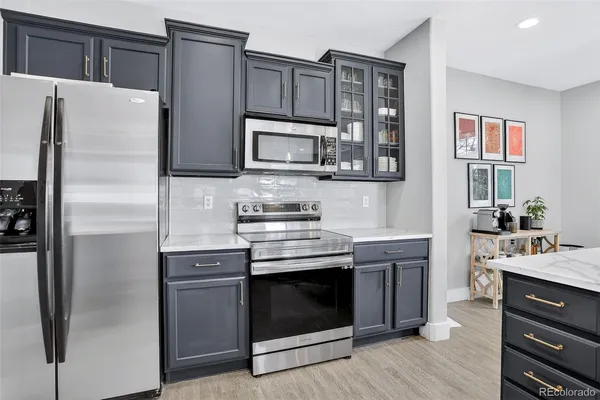 a kitchen with stainless steel appliances granite countertop a refrigerator stove and sink
