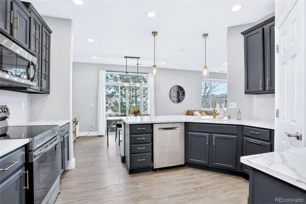 a large kitchen with stainless steel appliances granite countertop a sink counter space and wooden floor