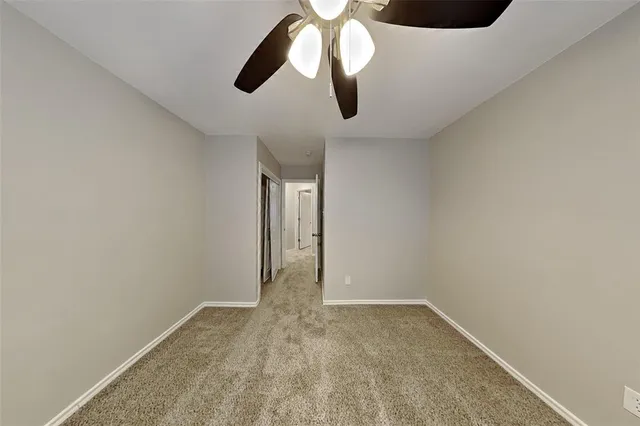 a view of empty room with ceiling fan