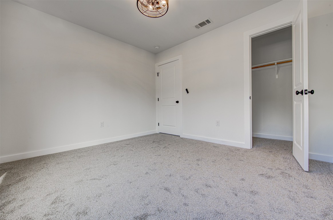 18414 Roundrock Road Jonestown, TX 78645 - Photo 20 of 30 Unfurnished bedroom featuring a closet and light carpet