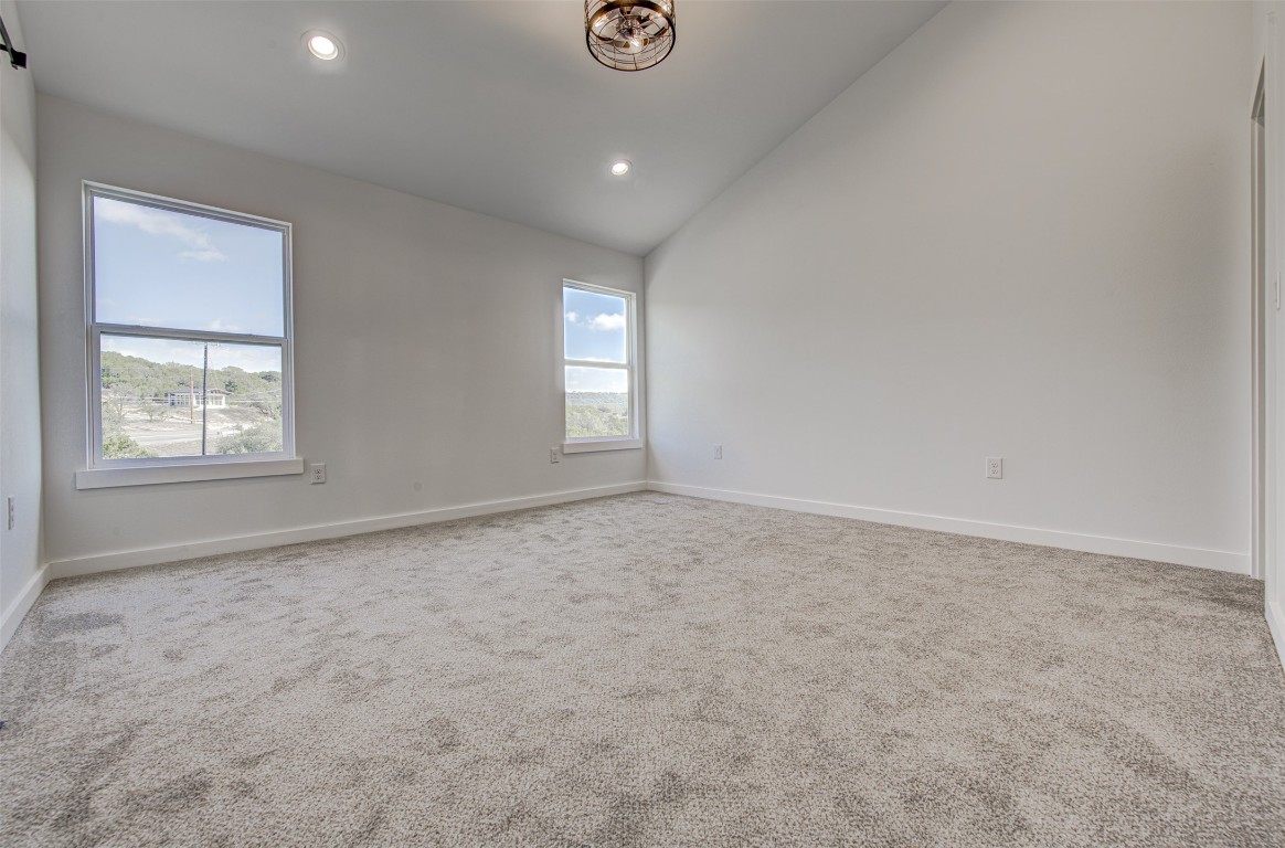 18414 Roundrock Road Jonestown, TX 78645 - Photo 21 of 30 Carpeted empty room with recessed lighting and high vaulted ceiling