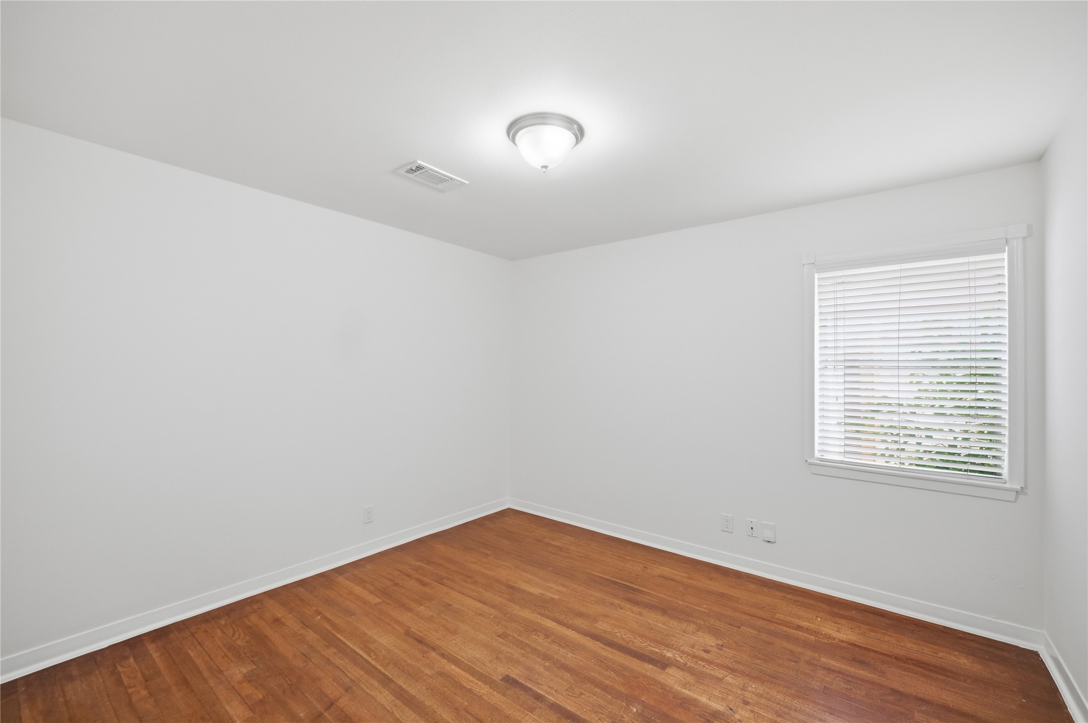 9524 Truscon Drive Houston, TX 77080 - Photo 15 of 30 an empty room with wooden floor and windows
