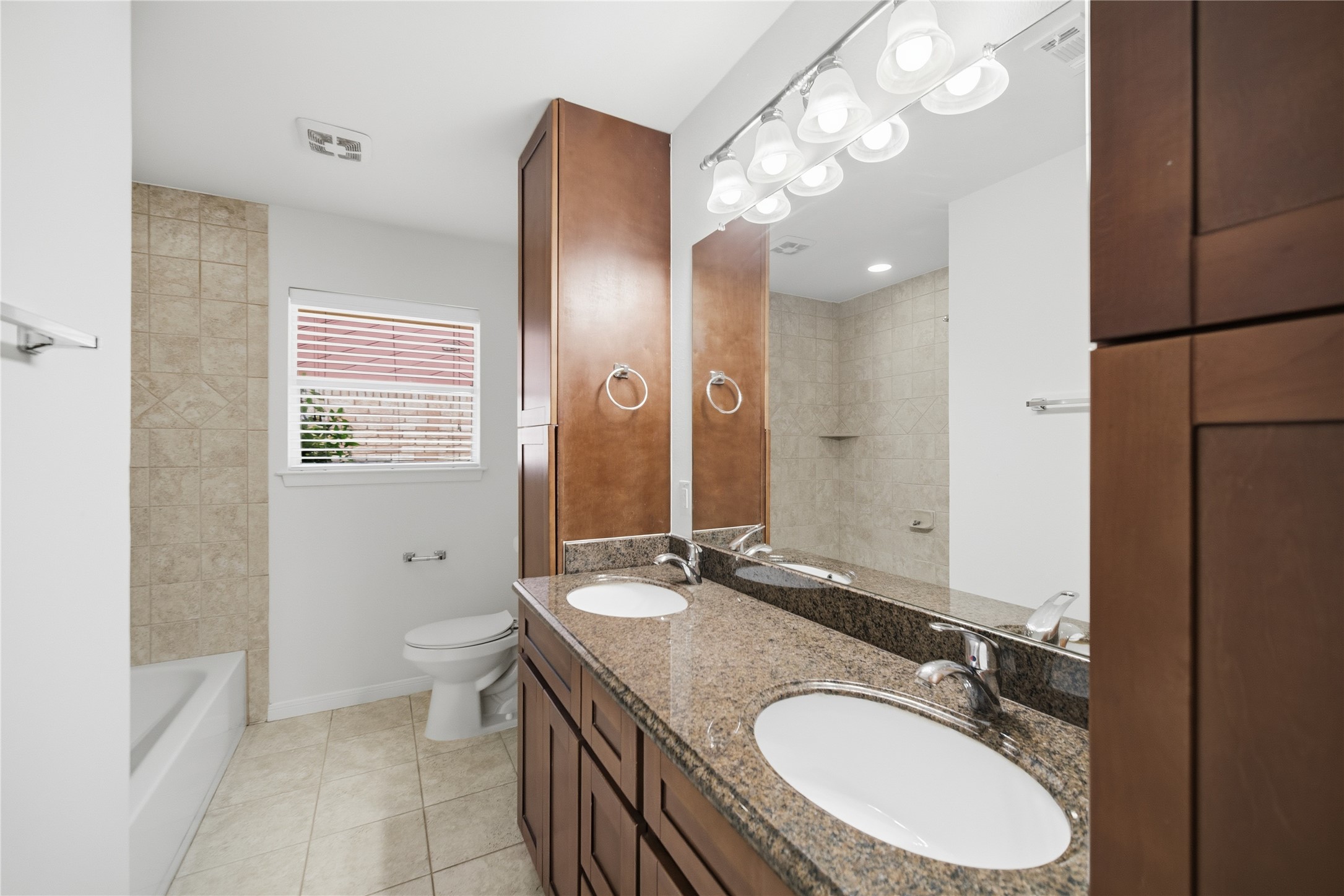 9524 Truscon Drive Houston, TX 77080 - Photo 17 of 30 a bathroom with a granite countertop double vanity sink a mirror and a toilet