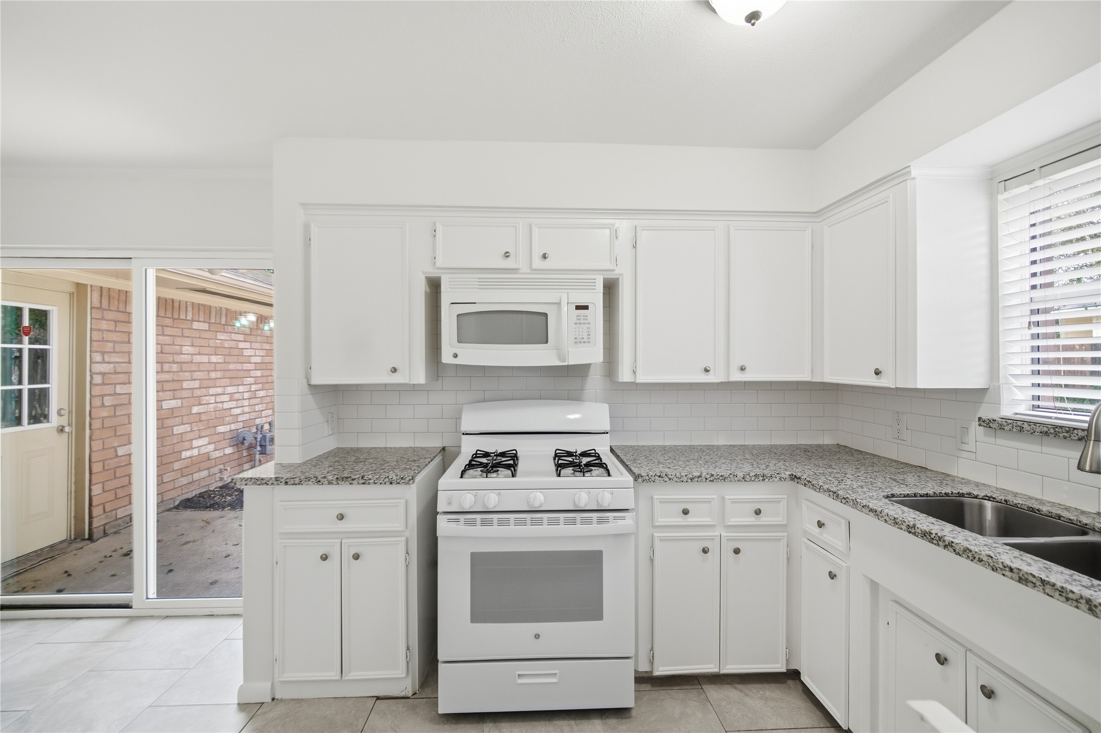 9524 Truscon Drive Houston, TX 77080 - Photo 9 of 30 Natural lighting shines through the glass door and windows of the kitchen.