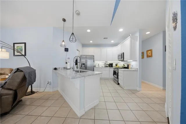 a kitchen with white cabinets and sink