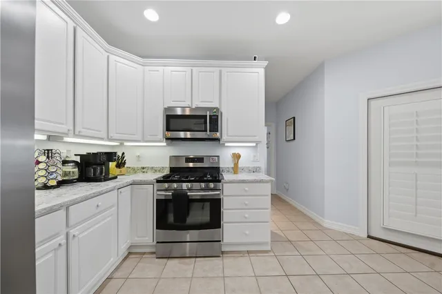 a kitchen with white cabinets and appliances