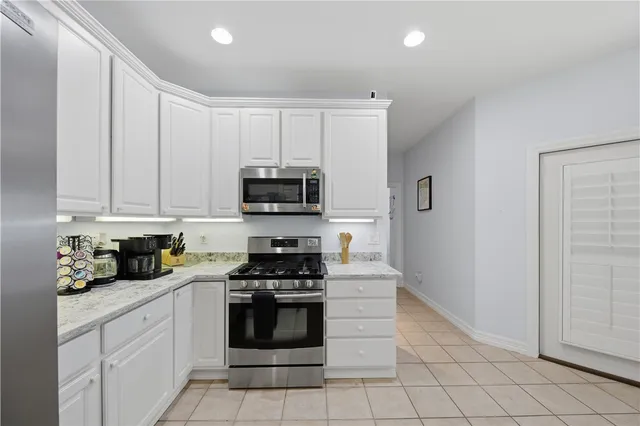 a kitchen with white cabinets and appliances