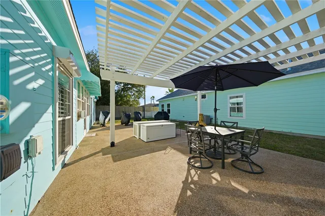 a view of a patio with table and chairs under an umbrella
