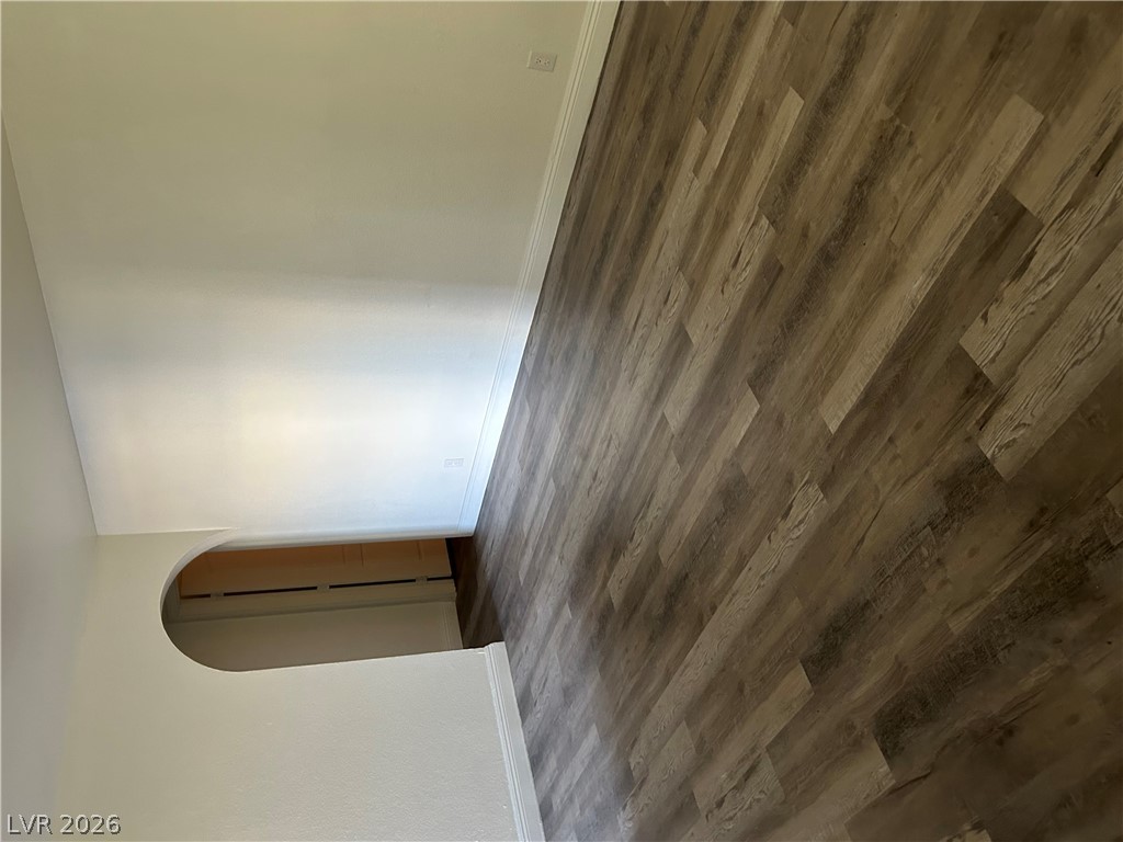1852 North Decatur Boulevard, Unit 103 Las Vegas, NV 89108 - Photo 5 of 10 Rich wood-look flooring extends through this inviting room, complemented by a graceful arched doorway.