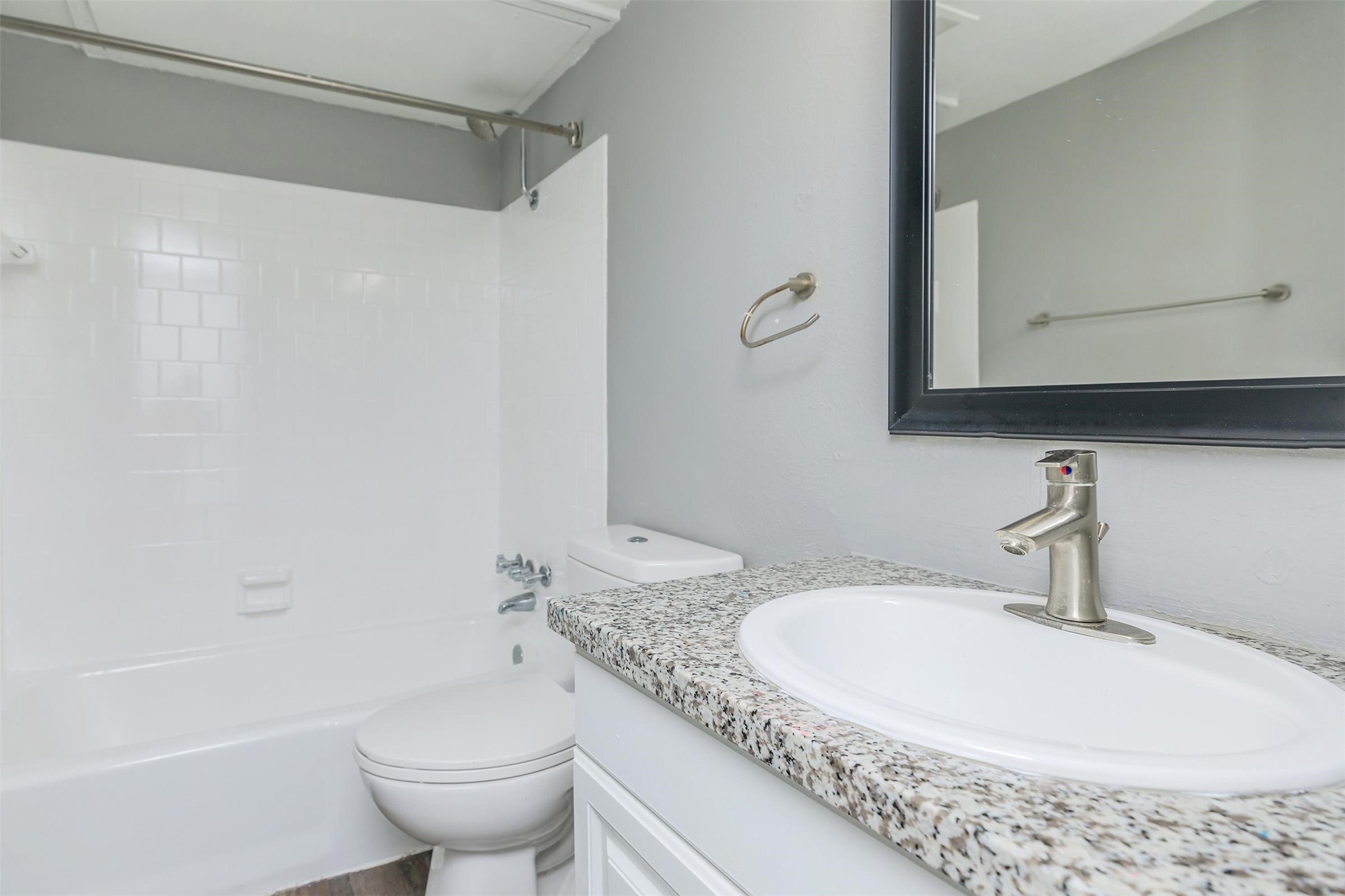 1212 Hampshire Lane, Unit 2091 Richardson, TX 75080 - Photo 19 of 40 a bathroom with a granite countertop sink a toilet and a bathtub