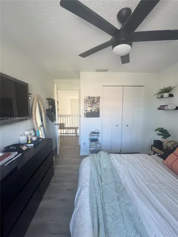 a bedroom with a bed and a flat tv screen on dresser
