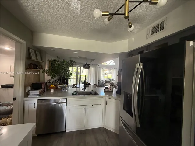 a kitchen with a sink stainless steel appliances and cabinets