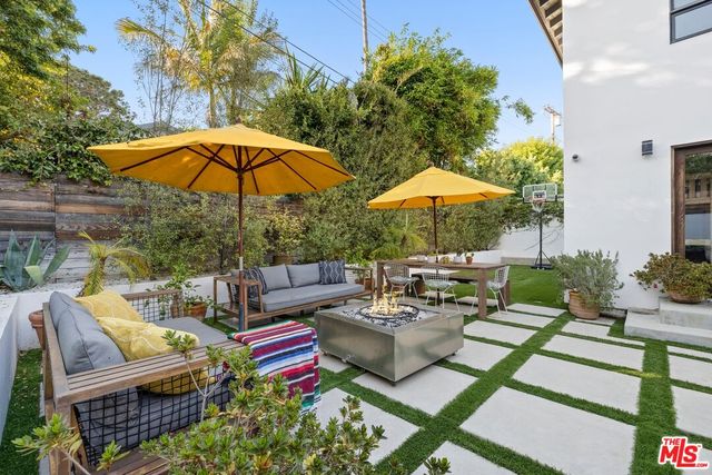 a couple of tables and chairs under an umbrella in patio