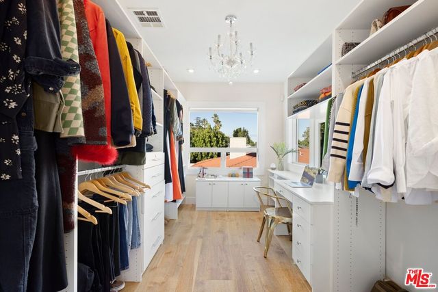 a view of walk in closet with clothes and shoes