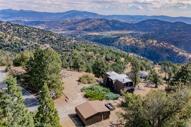 an aerial view of house with mountain in the background