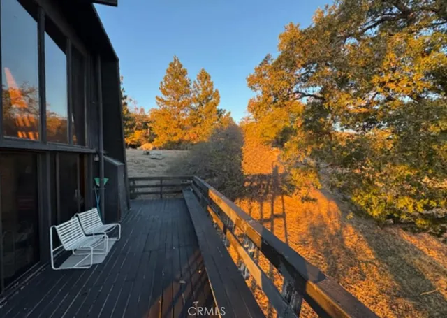 a view of balcony with wooden floor and fence
