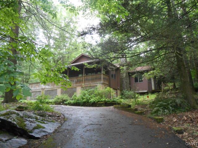 3497 Spruce Cabin Road Cresco, PA 18326 - Photo 1 of 22 a backyard of a house with plants and large trees