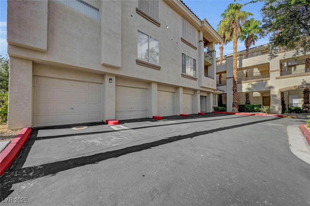 7147 South Durango Drive, Unit 304 Las Vegas, NV 89113 - Photo 1 of 27 View of building exterior featuring a garage