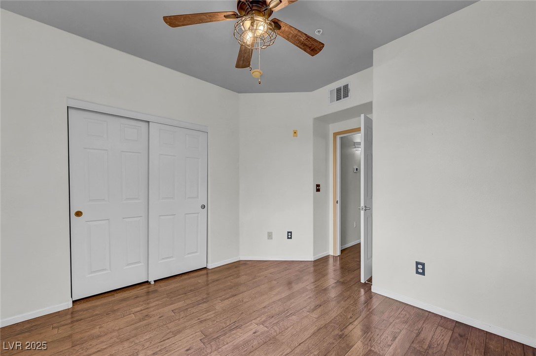 7147 South Durango Drive, Unit 304 Las Vegas, NV 89113 - Photo 14 of 27 Unfurnished bedroom with wood finished floors, a closet, and ceiling fan