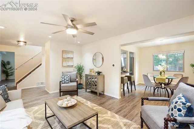 a living room with furniture kitchen view and a large window