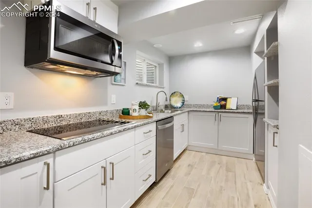 a kitchen with stainless steel appliances a stove microwave and sink