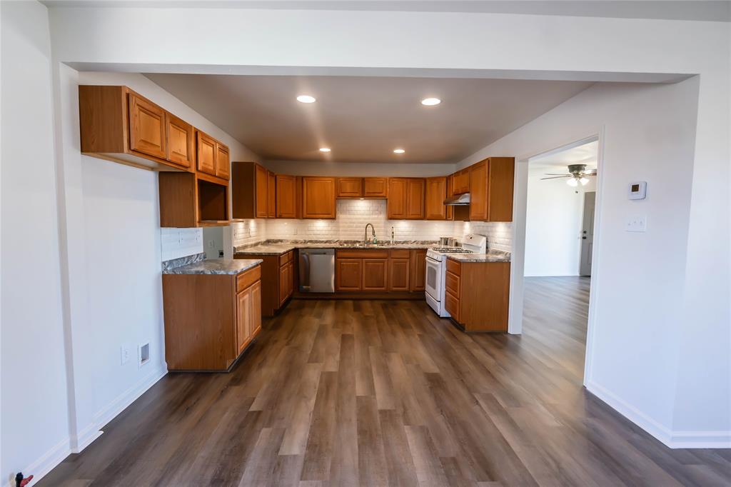 1226 Clay Street Nocona, TX 76255 - Photo 13 of 31 a kitchen with stainless steel appliances granite countertop a stove and a refrigerator