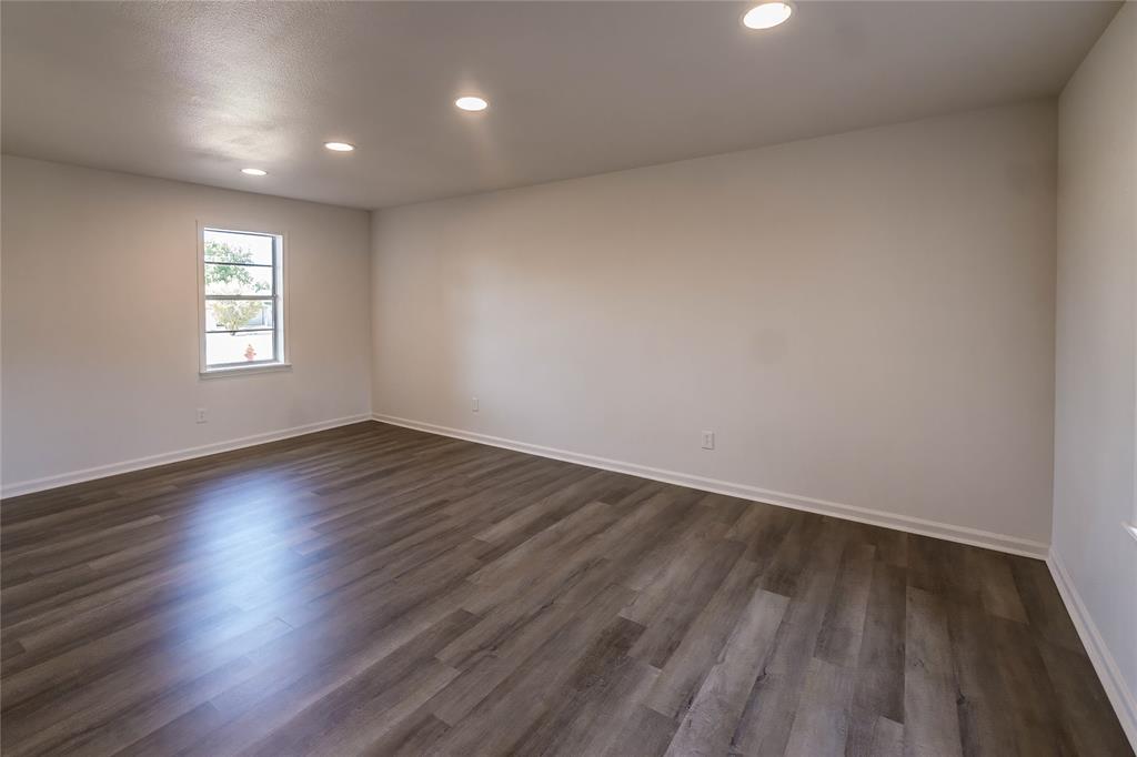 1226 Clay Street Nocona, TX 76255 - Photo 14 of 31 an empty room with wooden floor and windows