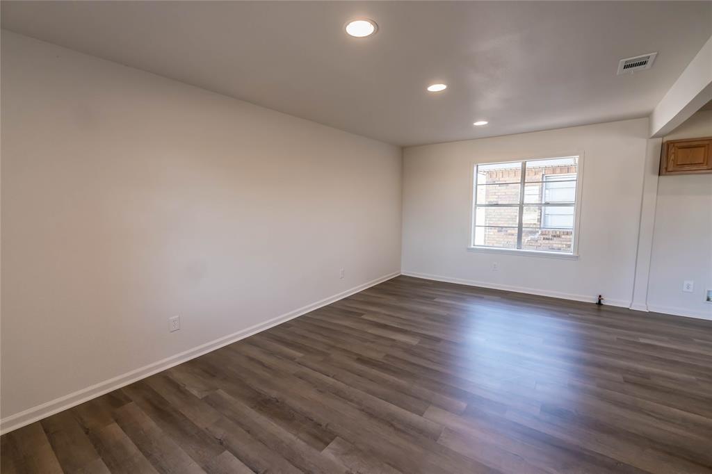 1226 Clay Street Nocona, TX 76255 - Photo 16 of 31 an empty room with wooden floor and windows