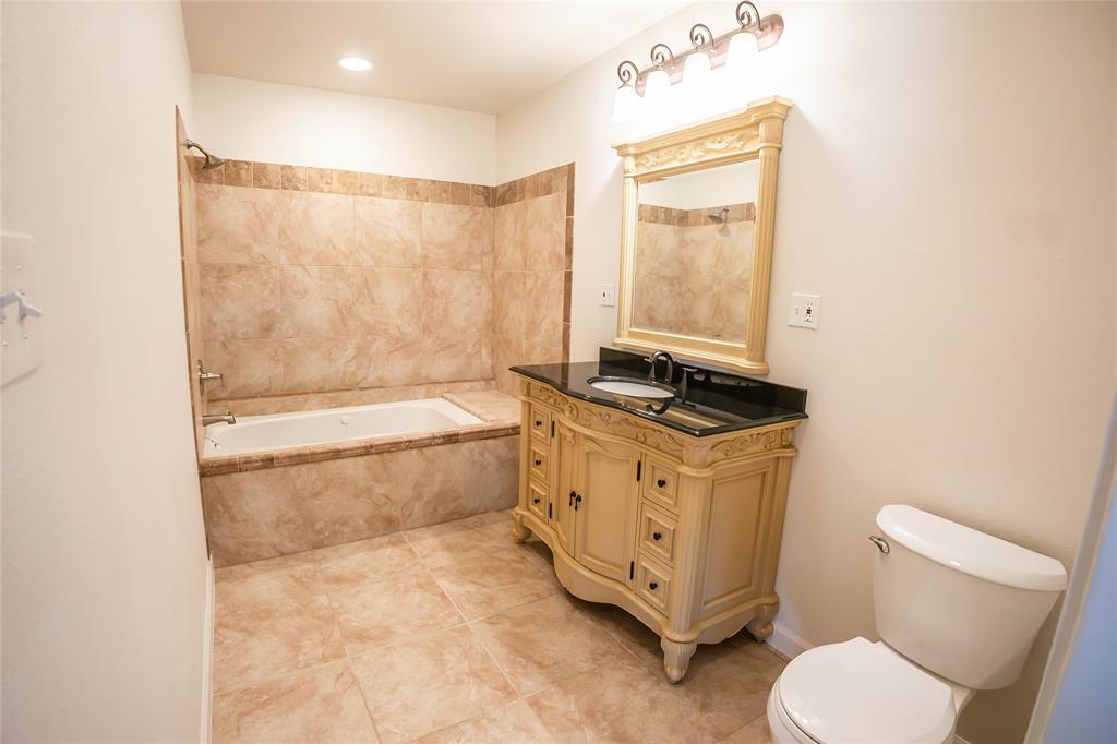 1226 Clay Street Nocona, TX 76255 - Photo 20 of 31 a bathroom with a granite countertop sink toilet and bathtub