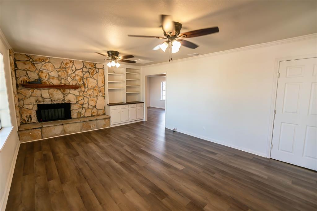 1226 Clay Street Nocona, TX 76255 - Photo 10 of 31 wooden floor in an empty room with a fireplace