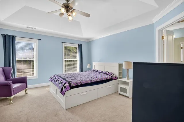 a bedroom with a bed couch chandelier and a window