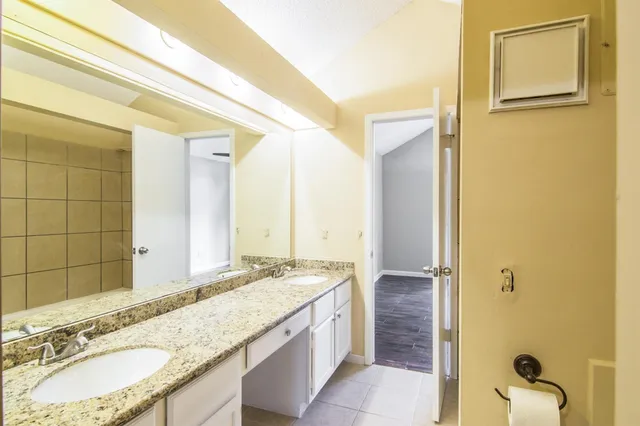 a bathroom with a granite countertop sink and a mirror