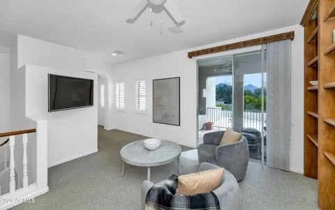a living room with furniture a flat screen tv and kitchen view