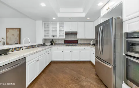 a kitchen with stainless steel appliances granite countertop a refrigerator and a stove top oven