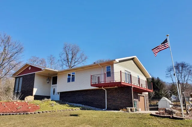 a front view of a house with a yard covered with snow