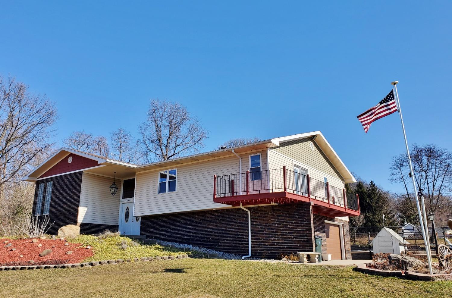 a front view of a house with a yard covered with snow