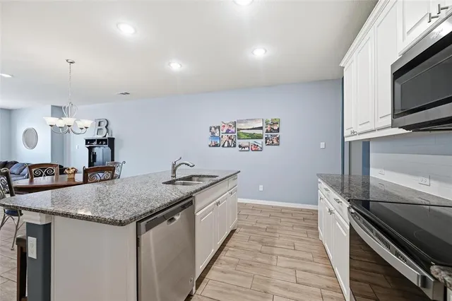 a kitchen with granite countertop a sink and stainless steel appliances