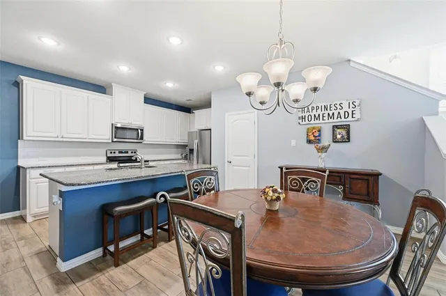 a kitchen with stainless steel appliances granite countertop a sink a stove and a refrigerator