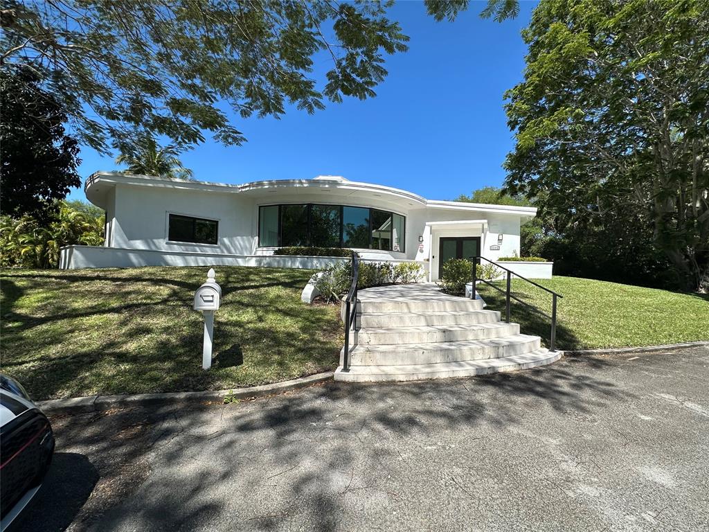 6205 Southwest 108th Street Pinecrest, FL 33156 - Photo 2 of 28 a front view of house with yard and trees in the background