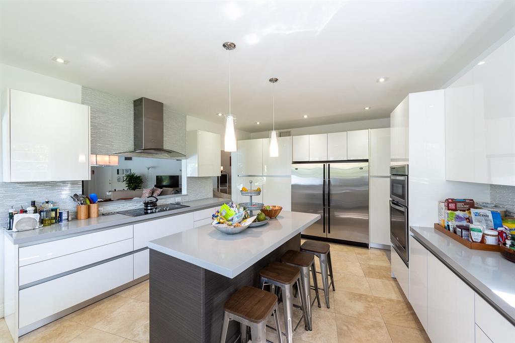 6205 Southwest 108th Street Pinecrest, FL 33156 - Photo 9 of 28 a kitchen with stainless steel appliances a sink a stove a refrigerator cabinets and wooden floor