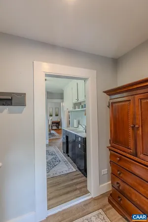 a view of a hallway and a livingroom with wooden furniture