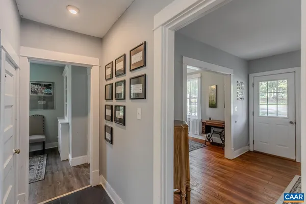 a view of a hallway with wooden floor and a bedroom