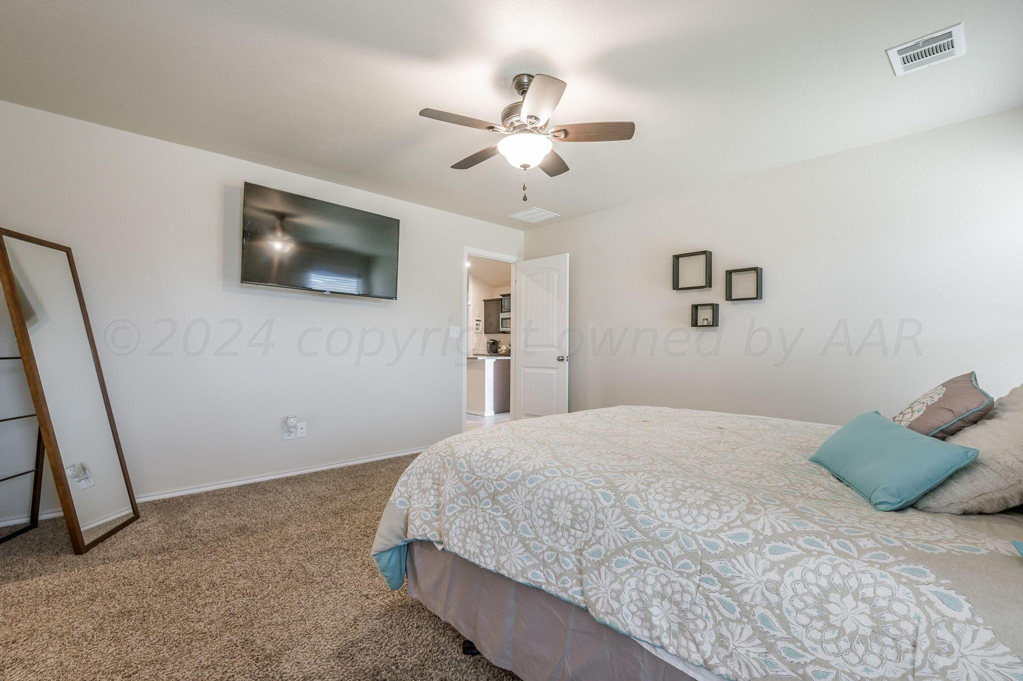 4806 Eberly Street Amarillo, TX 79118 - Photo 11 of 19 a bedroom with a large bed and a flat screen tv