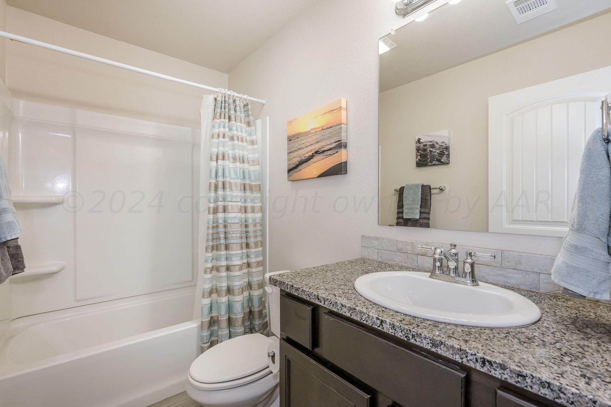 4806 Eberly Street Amarillo, TX 79118 - Photo 16 of 19 a bathroom with a granite countertop sink toilet and shower