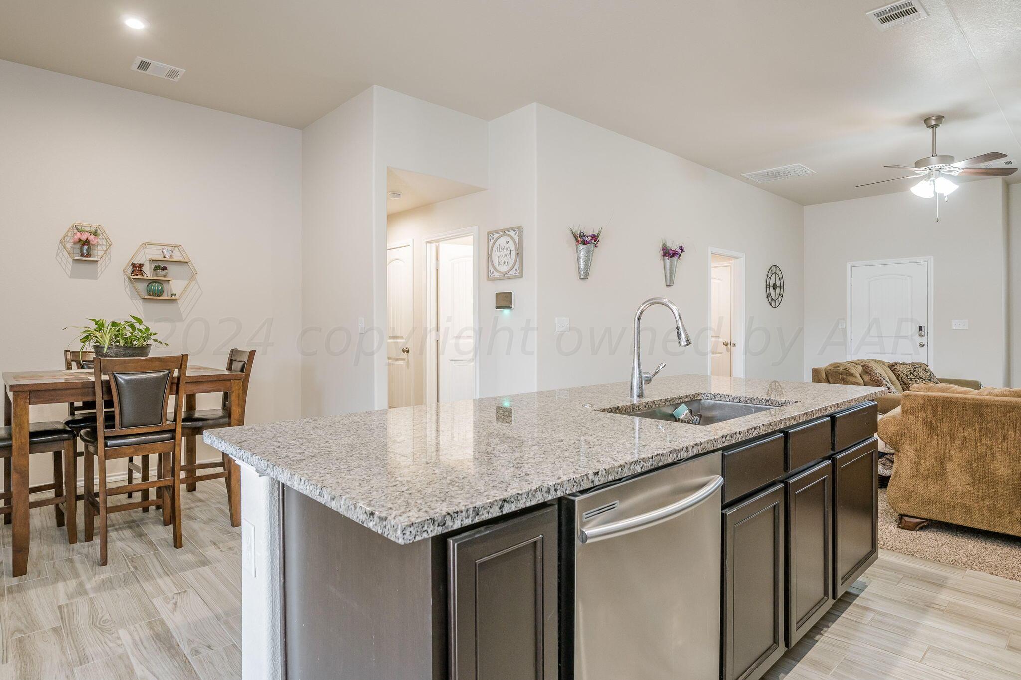 4806 Eberly Street Amarillo, TX 79118 - Photo 8 of 19 a kitchen with granite countertop kitchen island a sink and a table