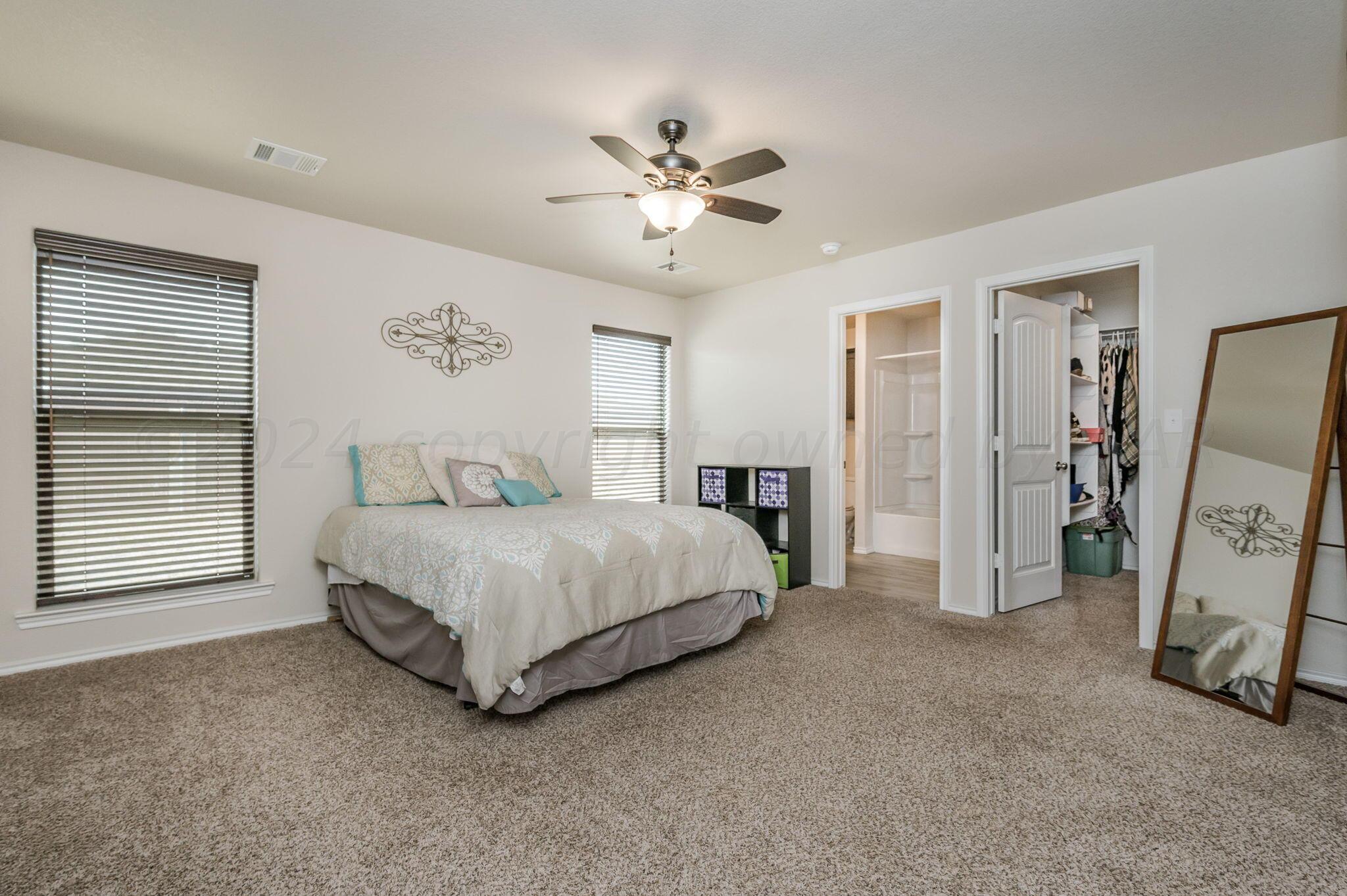 4806 Eberly Street Amarillo, TX 79118 - Photo 10 of 19 a spacious bedroom with a bed and a flat screen tv