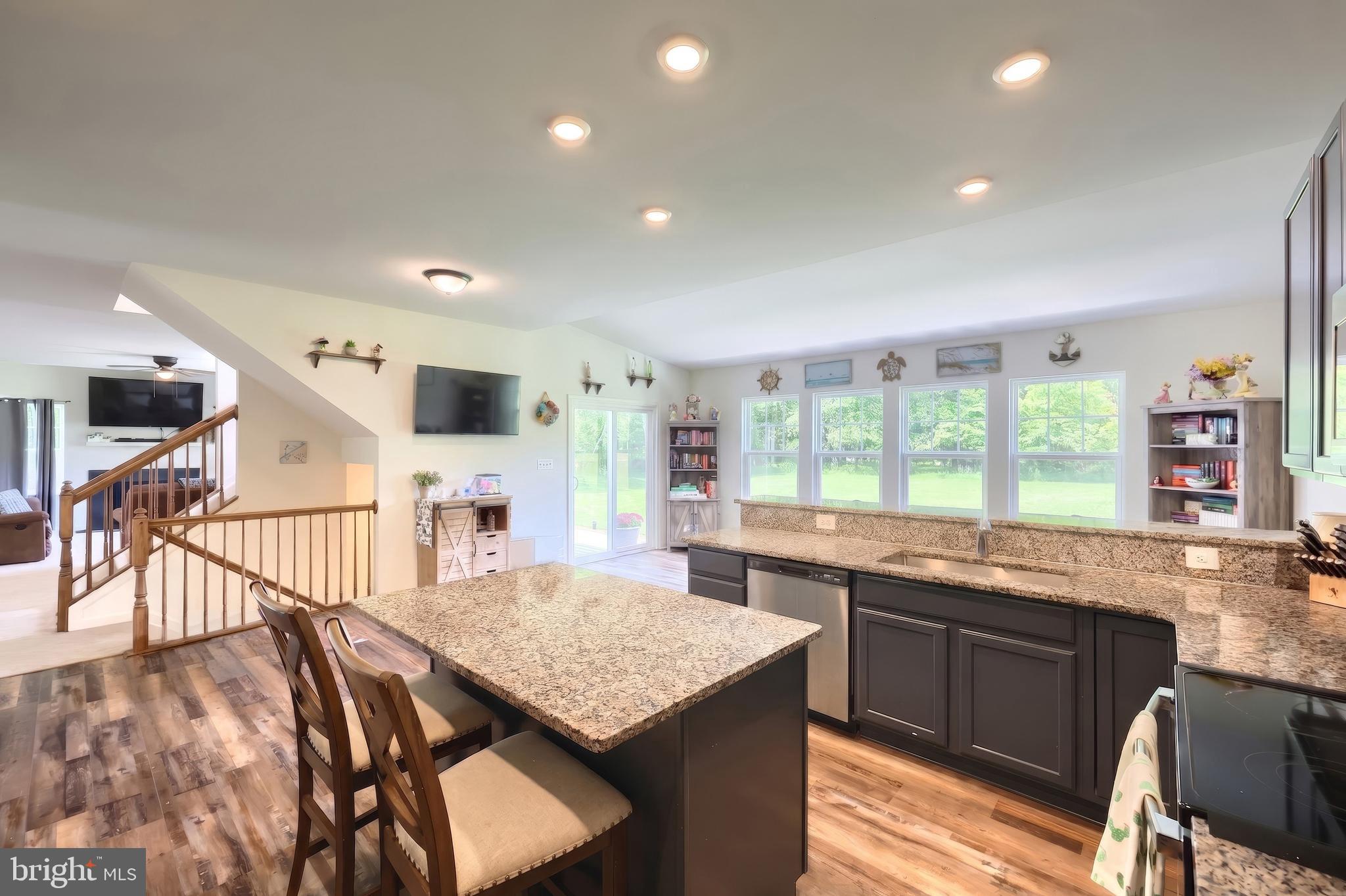 2741 Cold Springs Road Orrtanna, PA 17353 - Photo 22 of 52 a kitchen with stainless steel appliances granite countertop a kitchen island hardwood floor sink stove dining table and chairs