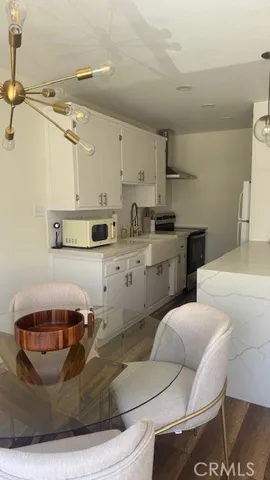 a kitchen with stainless steel appliances kitchen island granite countertop a sink and white cabinets